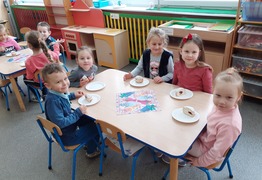 Dzieci z grupy Pracusie (Borówko Stare) podczas świętowania dnia Tłusty Czwartek. Dzieci siedzą przy stolikach i jedzą pączki (photo)