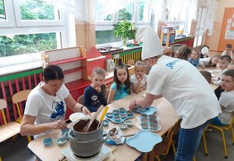 Dzieci z grupy Pracusie z panią Elą i panią Nataszą podczas pieczenia smerfowych babeczek. Dzieci są ubrane w biało-niebieskie barwy (photo)